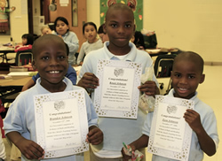 three boys holding graduation certificates